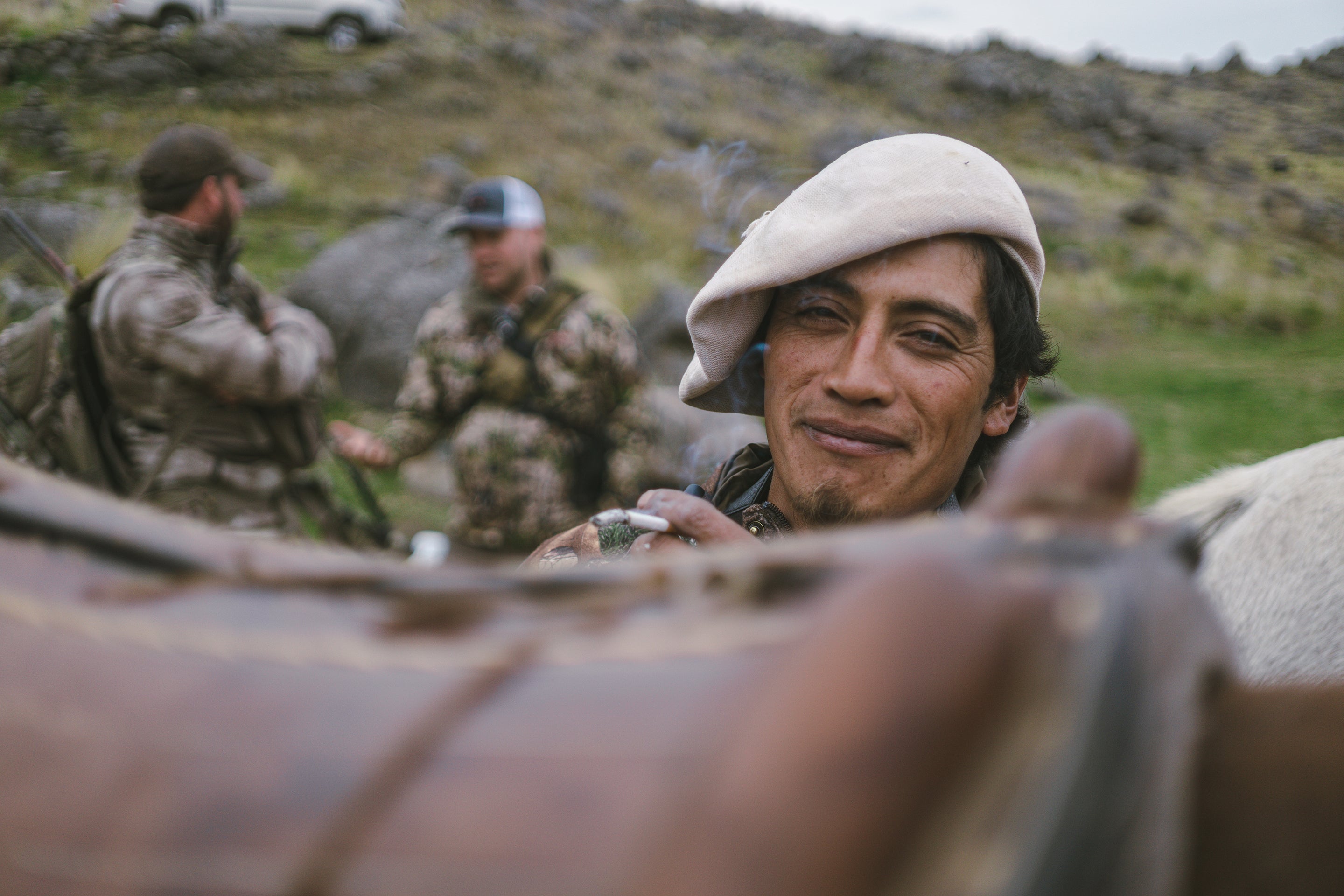 An Argentinan man saddles a horse with a slight smile.