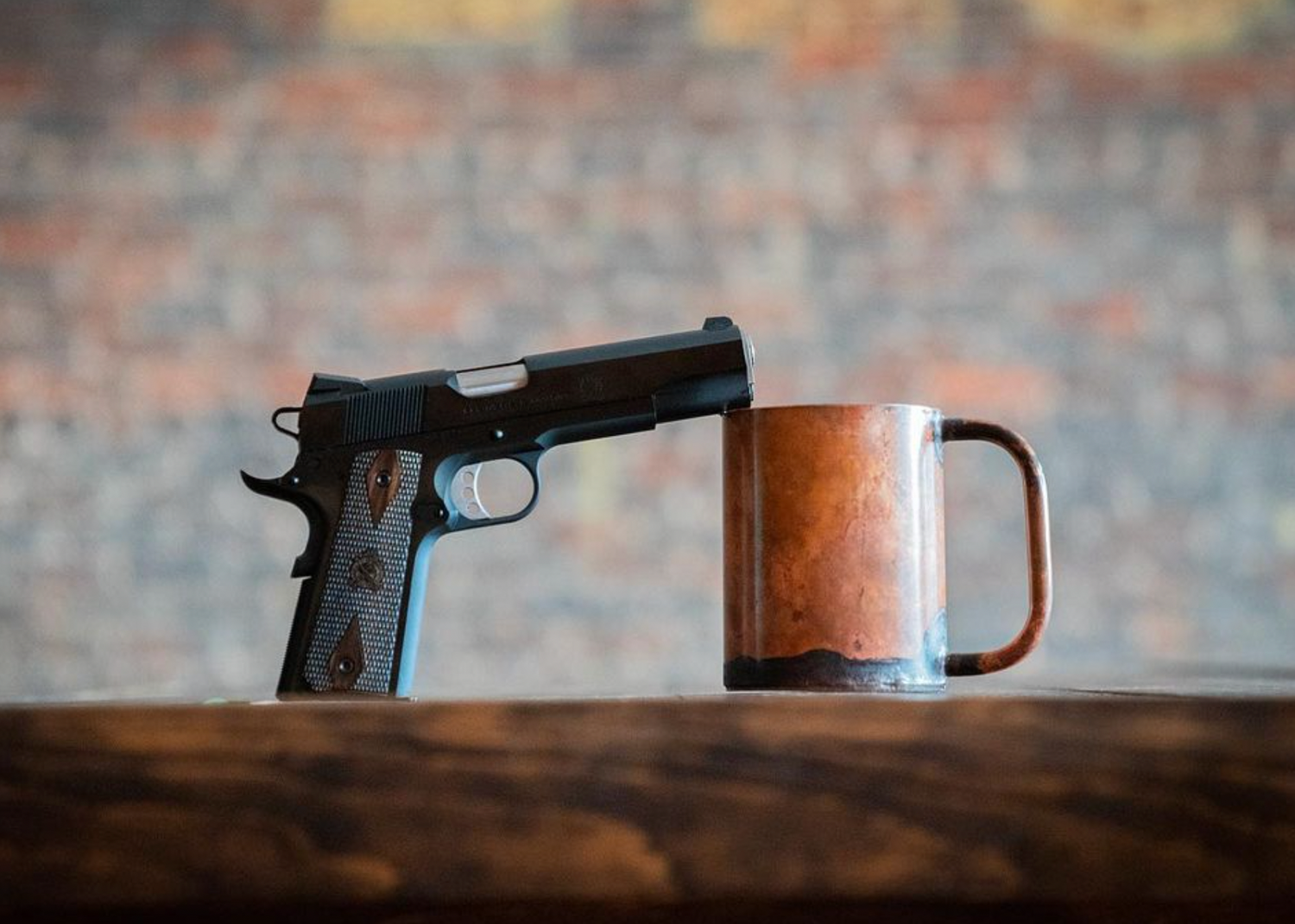 Copper Field Ethos Everything Mug sitting next to a pistol on a table.